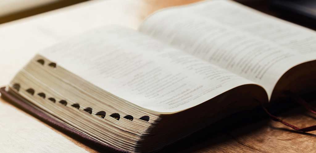 photo of an open bible sitting on a table